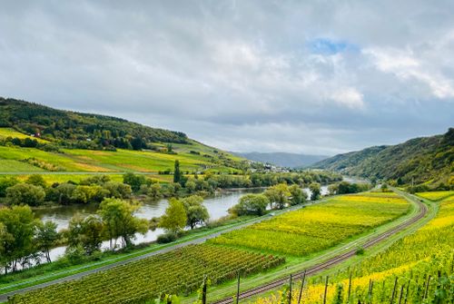 Free Picturesque view of German countryside featuring rolling hills, river, and farmland. Stock Photo