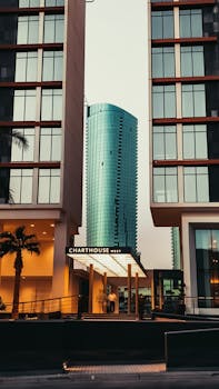 A city view showcasing modern urban architecture with a central glass skyscraper at dusk.