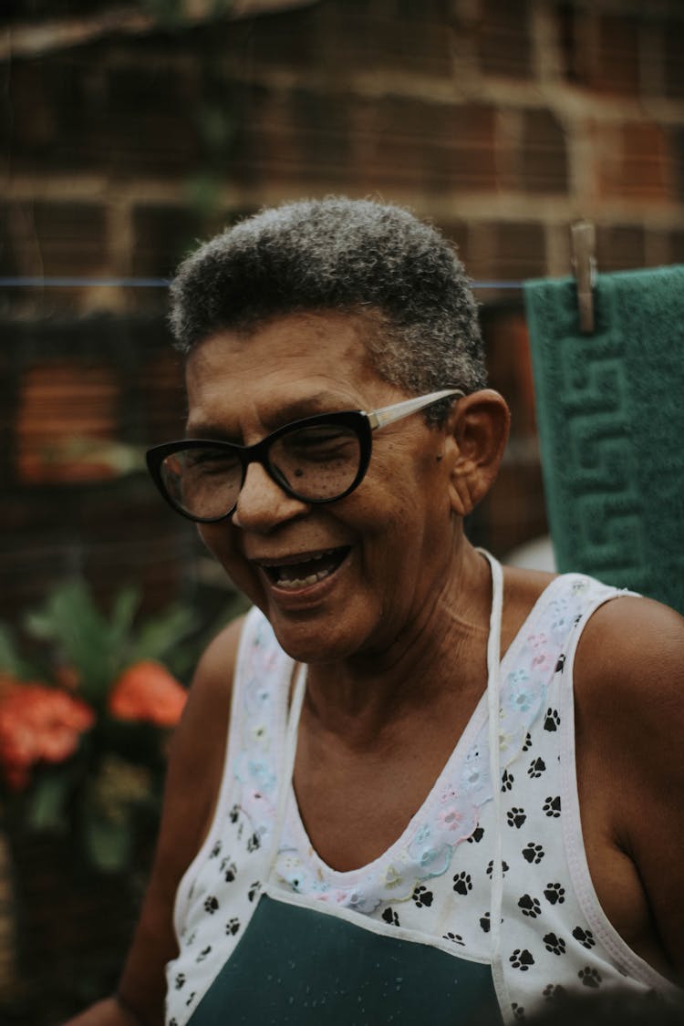 An Elderly Woman In White Top Laughing