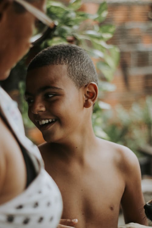 A Topless Boy Smiling