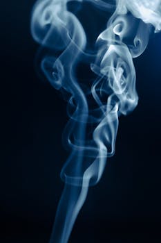 Captivating close-up of swirling smoke patterns against a dark background, creating an ethereal atmosphere.