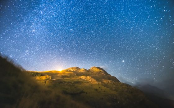 Capture of the starry night sky over the majestic Écrins National Park mountains in France.