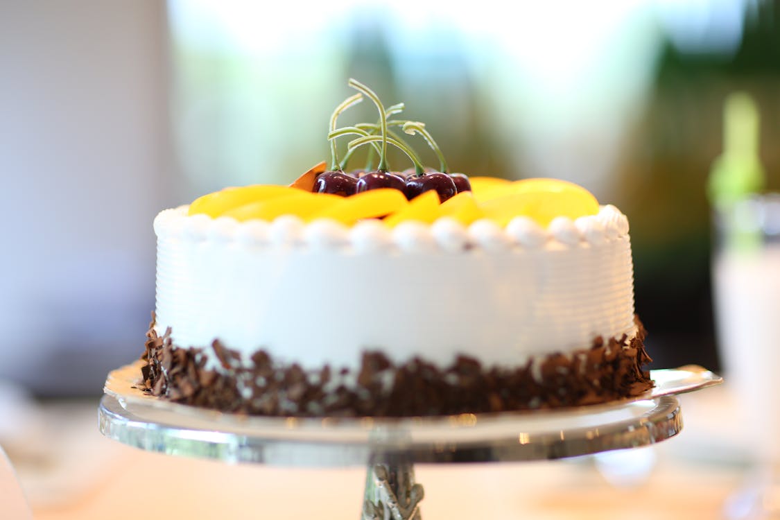 노란색 슬라이스 과일을 얹은 흰색 원형 케이크