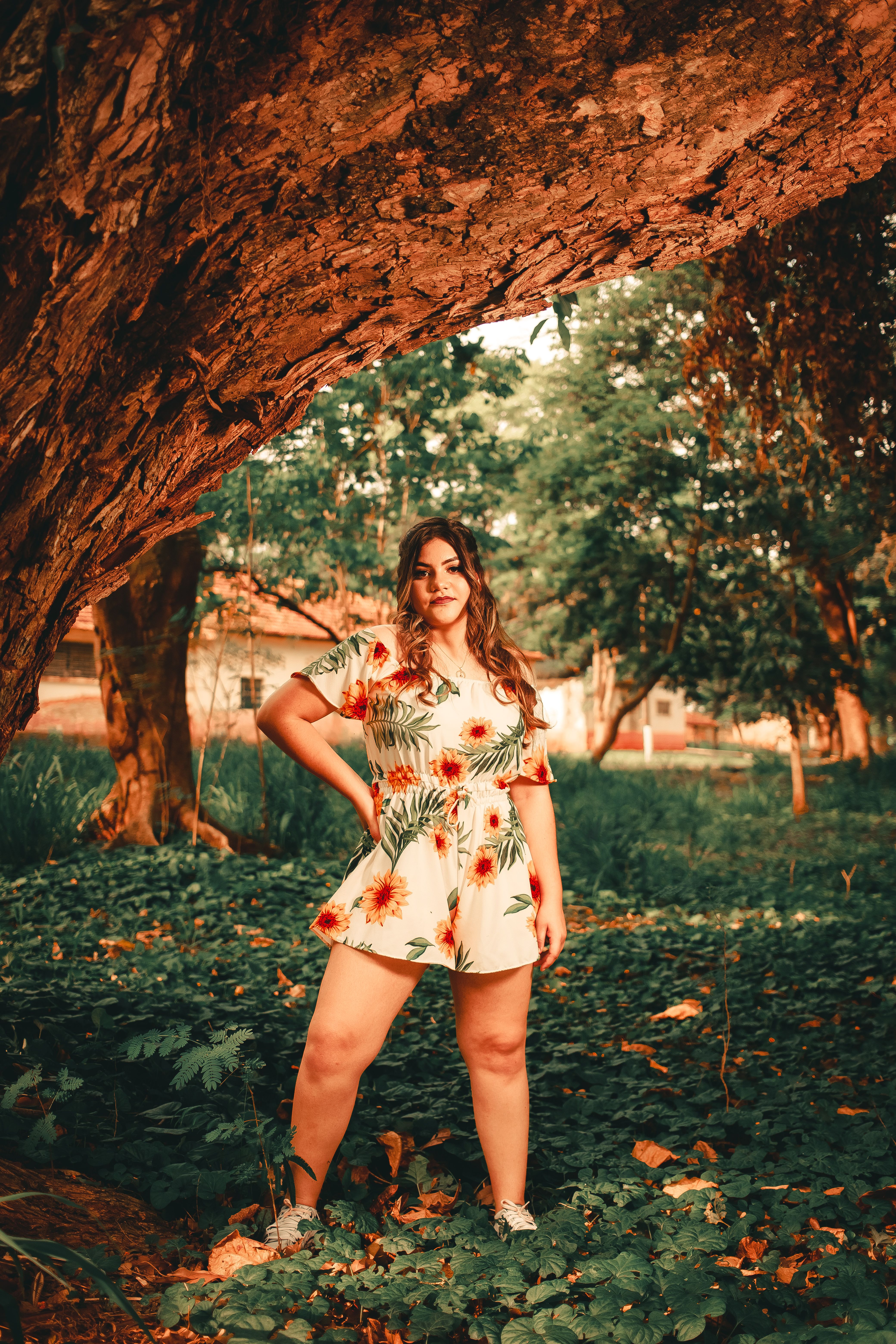 Woman in Floral Dress Standing Beside a Tree · Free Stock Photo