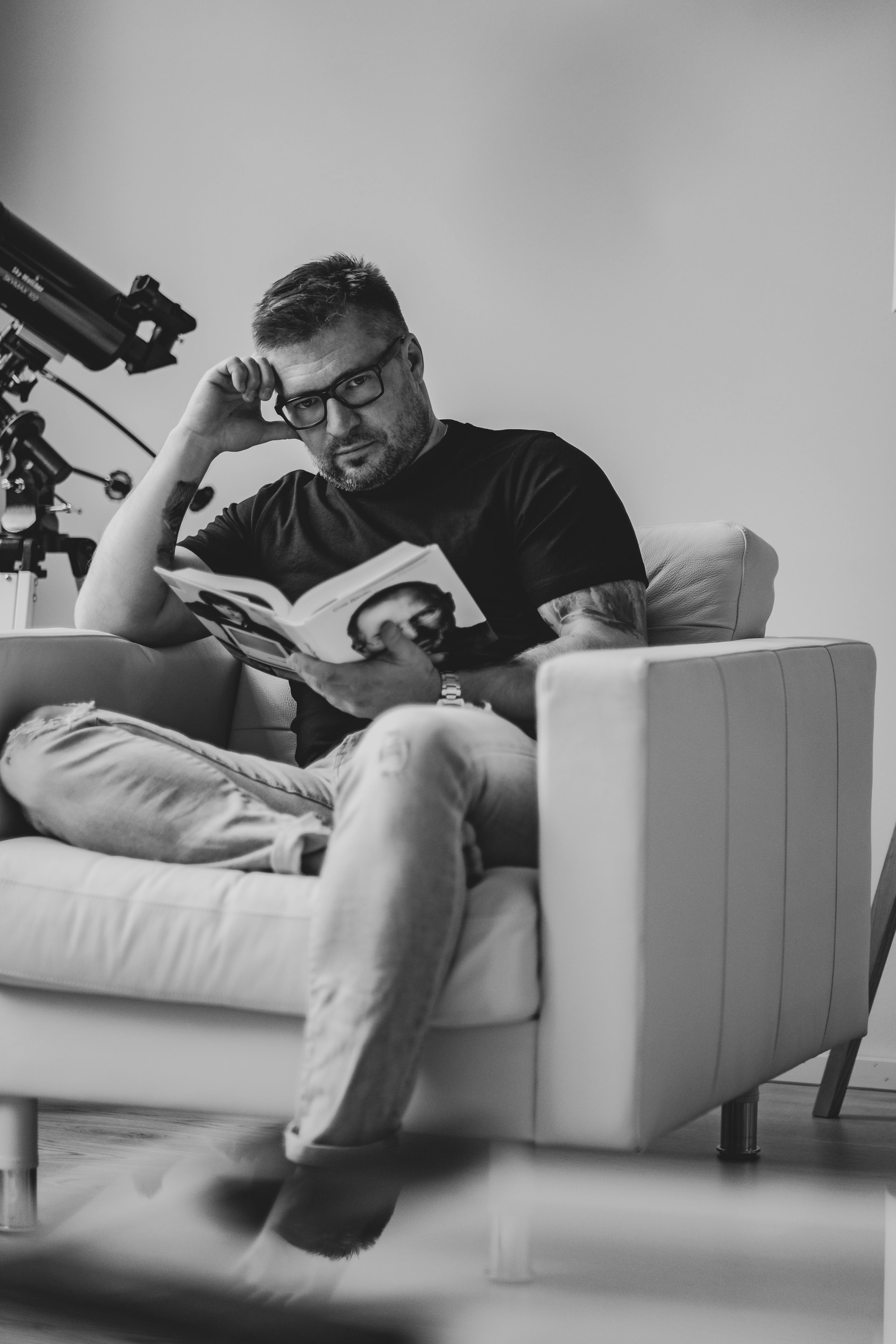 Man sitting in a modern chair, reading a book indoors in Finland.