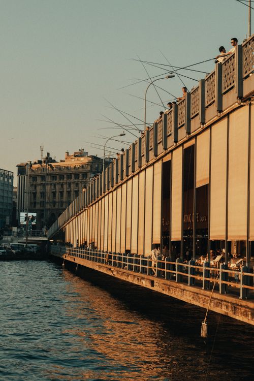 Free Sunlit view of Galata Bridge in Istanbul during the golden hour, reflecting on the water. Stock Photo