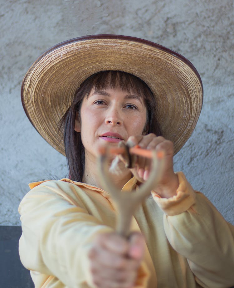 A Woman Holding A Slingshot