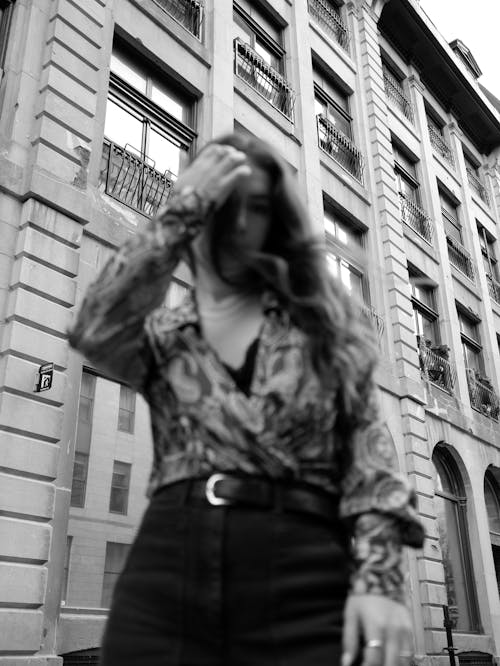 Grayscale Photo of Woman Posing In Front of a Building 