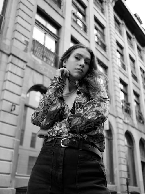 Grayscale Photo of Woman in Printed Long Sleeve in Low Angle Shot