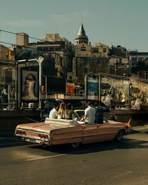 Free A retro convertible with passengers on a street in Istanbul, showcasing city life. Stock Photo