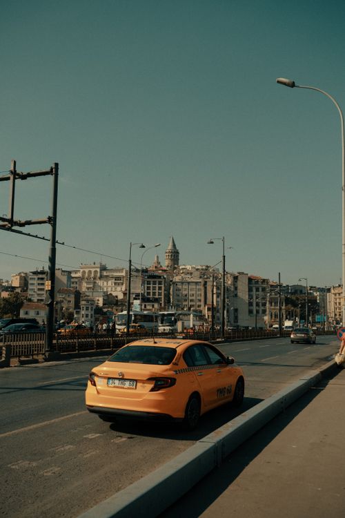 Free Back view of yellow taxi on Galata Bridge with Istanbul skyline and Galata Tower. Stock Photo