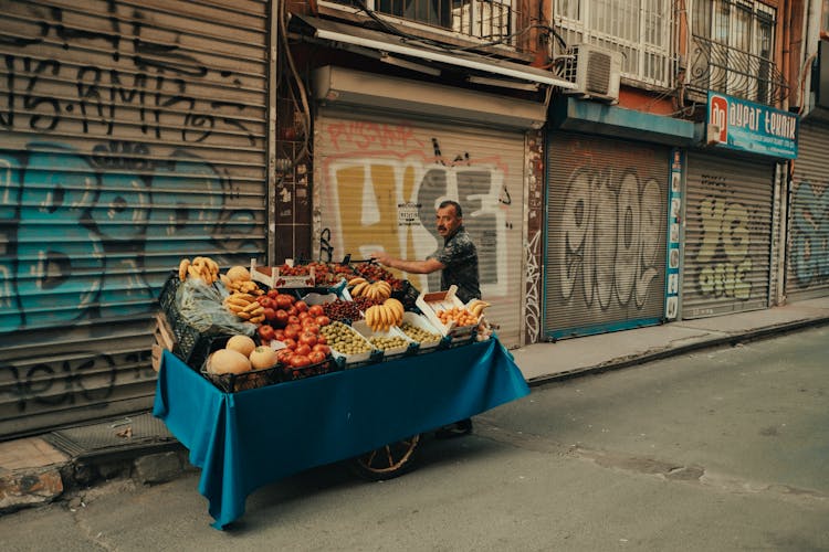 A Man Selling Fruit On A Cart