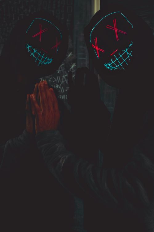 Free Dark themed photo featuring an eerie masked figure with neon lights, captured indoors. Stock Photo