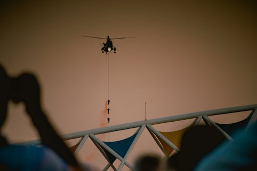 Soldiers Hanging on a Line Attached to a Flying Helicopter 