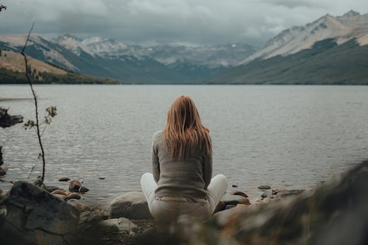 Woman Sitting By Sea