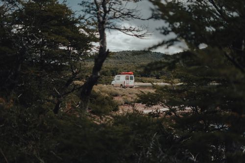 Free Van parked amidst lush wilderness, ideal for travel and adventure enthusiasts. Stock Photo