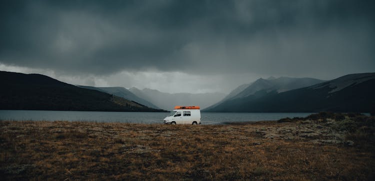 Storm Clouds Over Van Parked By Fjord