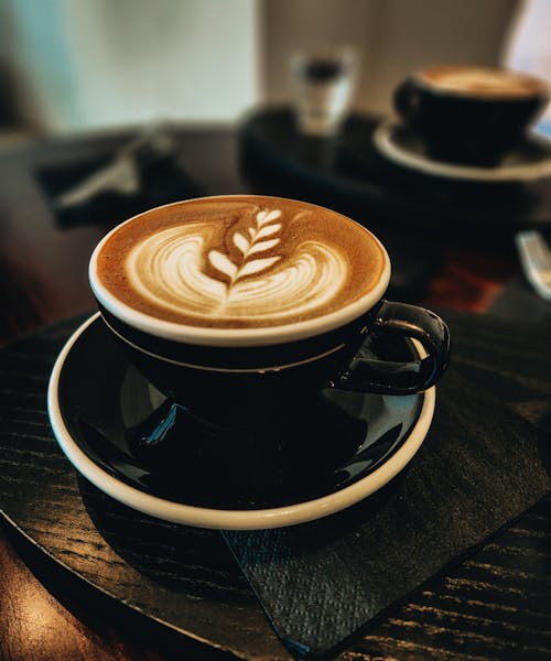 Close-Up Shot of Latte Art Coffee in Black Ceramic Cup