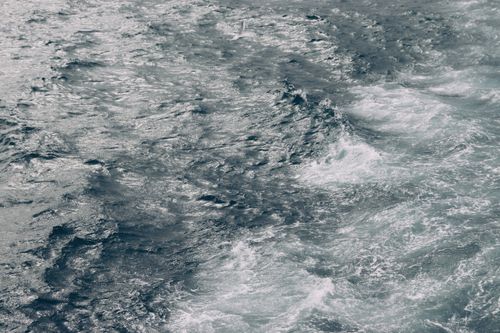 Free An aerial view captures the dynamic movement of ocean waves in calming blue tones. Stock Photo