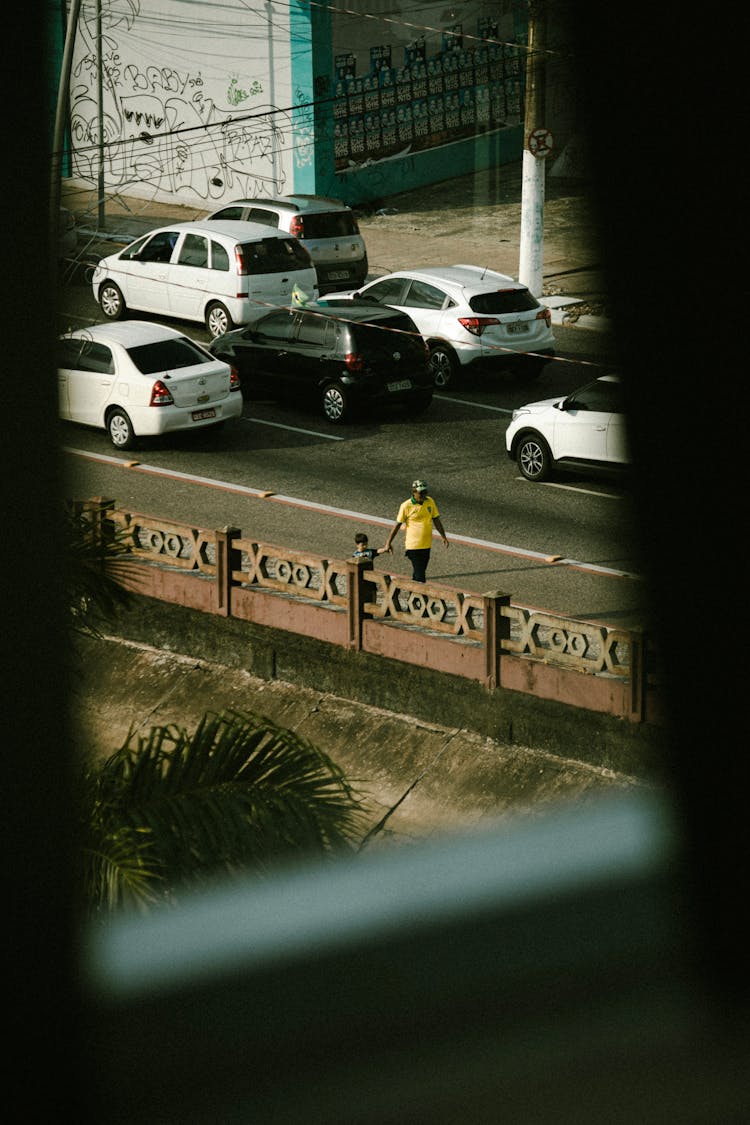 Parent Walking With Child Near Cars On Street