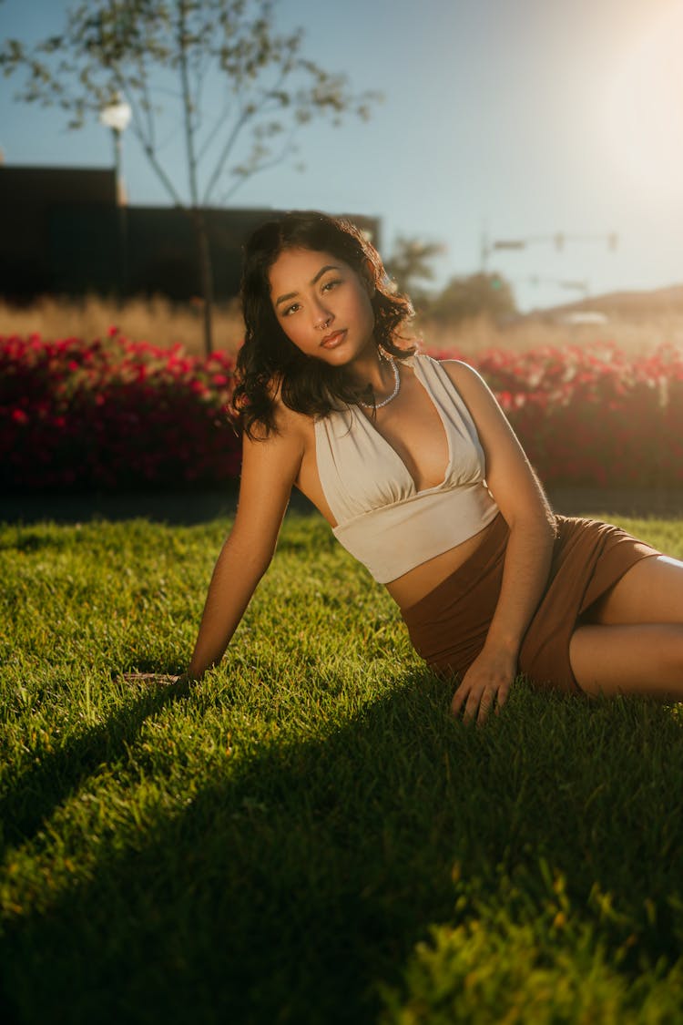 Woman In Mini Sitting On Grass