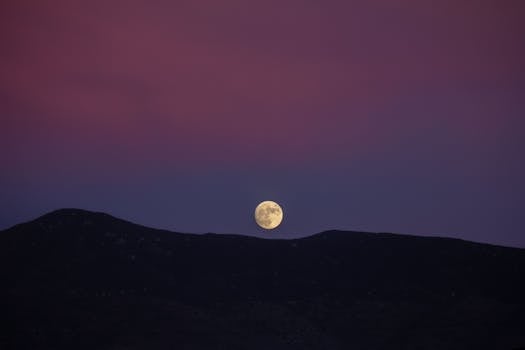 Vibrant twilight scene of a full moon over the Guadalupe Mountains, Mexico.