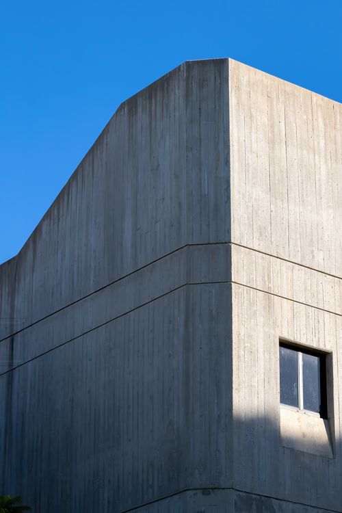 Free Minimalist concrete building facade with clear blue sky background. Stock Photo