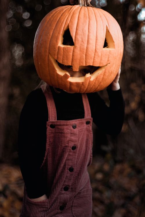 Free A child wearing a pumpkin on their head, celebrating Halloween outdoors in Smiths Falls, Canada. Stock Photo