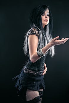 Studio portrait of a young woman in gothic fashion with dark, stylish clothing and striking makeup.