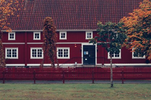 Free A classic red building with white windows and a fence in Jönköping, Sweden during autumn. Stock Photo
