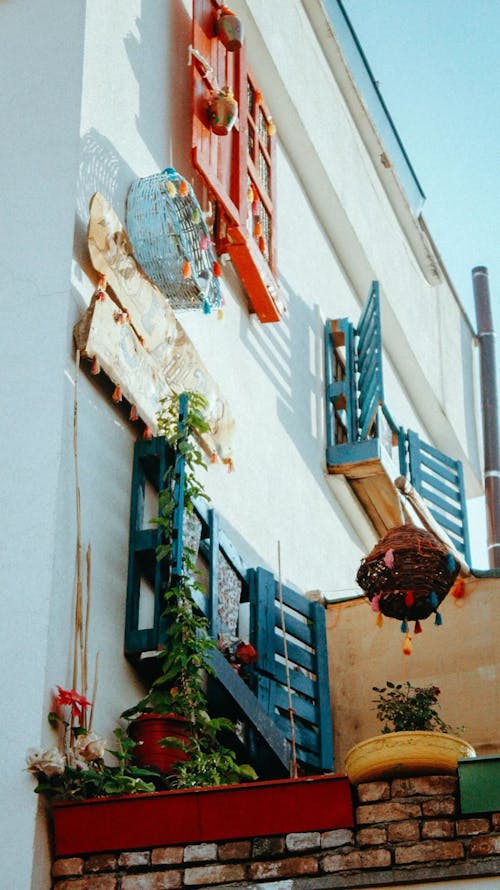 Free Exterior of a Building with Decorations, Plants and Wooden Window Shutters  Stock Photo