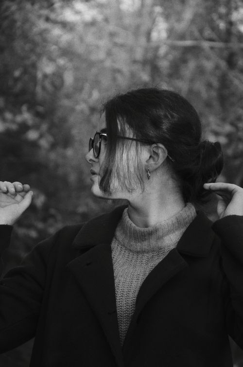 Free Monochrome side-profile portrait of a woman in eyeglasses outdoors. Stock Photo