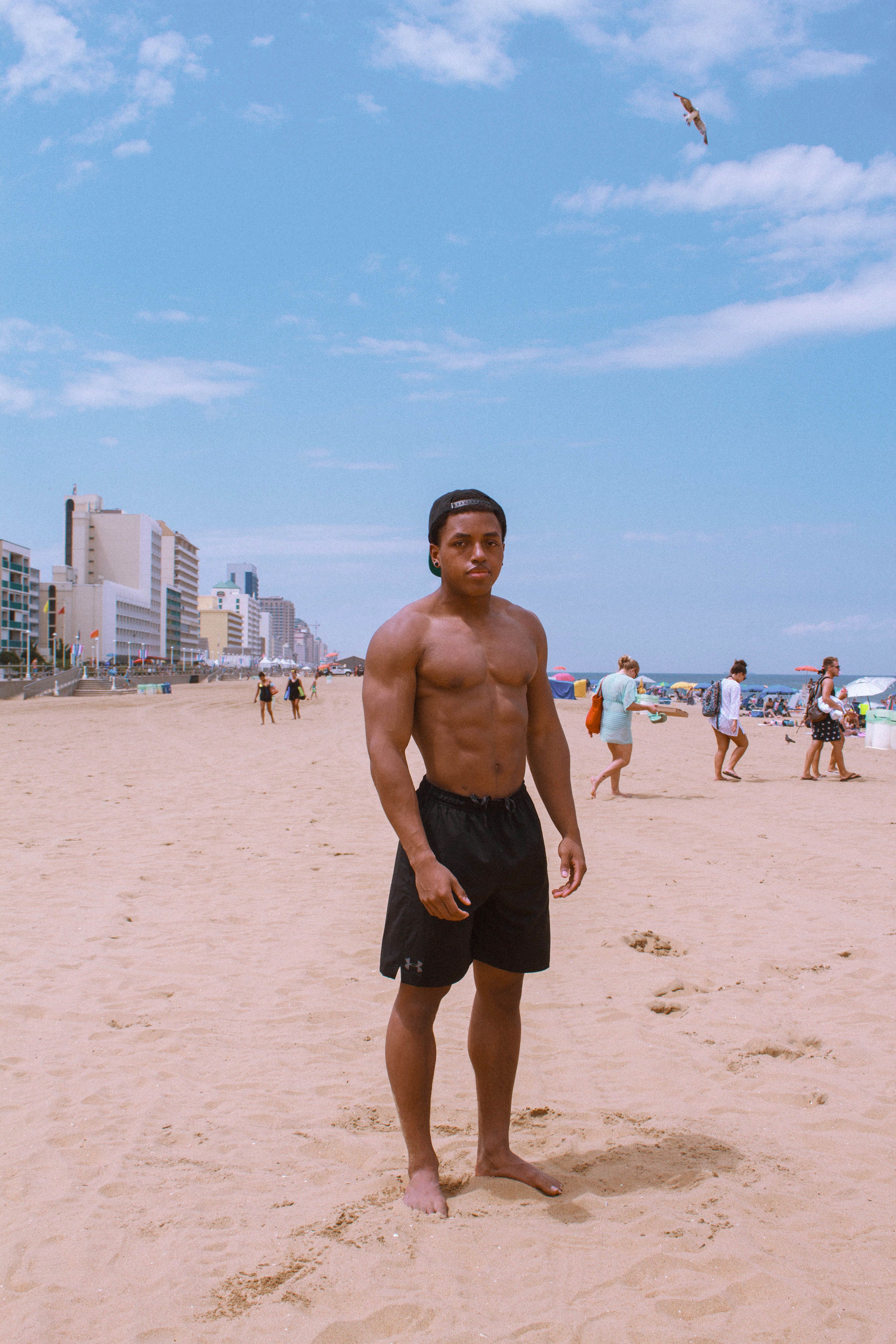 Athletic man posing on a sunny day at Virginia Beach, showcasing beach life.