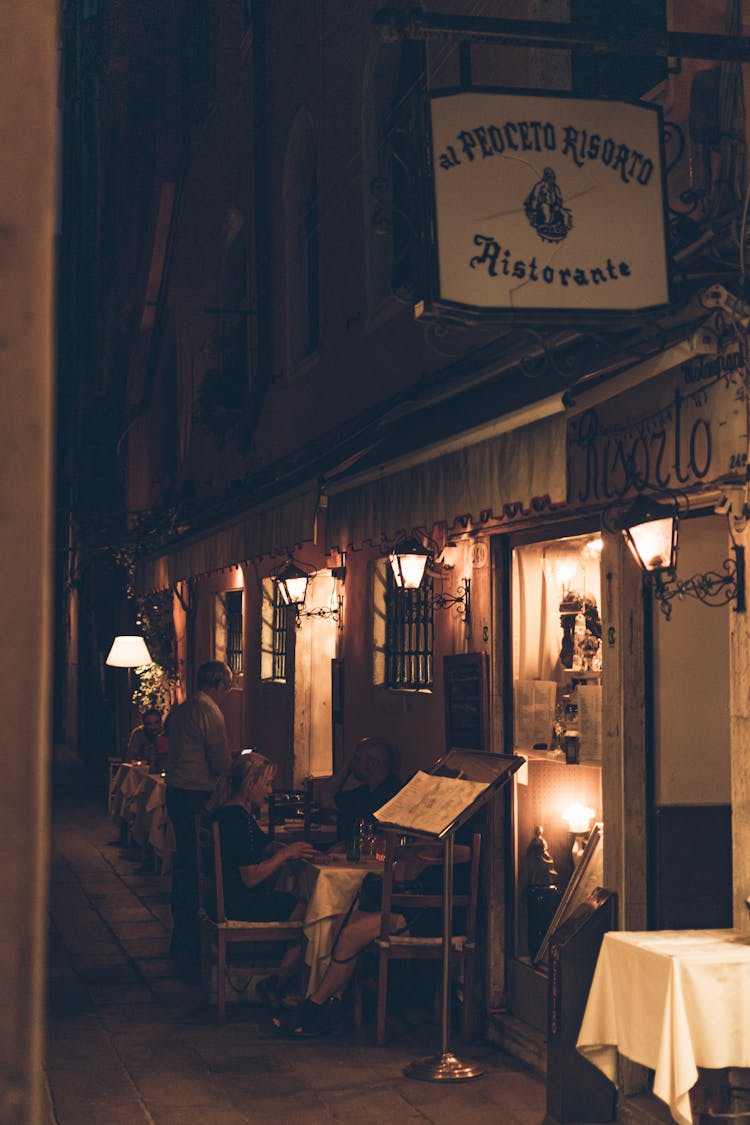 People Sitting On Chairs In Restaurant During Night Time