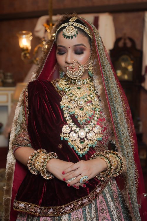 Free Stunning South Asian bride adorned with intricate traditional jewelry and saree indoors. Stock Photo