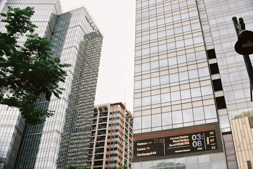 Modern skyscrapers featuring a digital display, showcasing a bustling urban environment.
