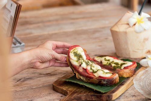 Free Person Hand Holding Sandwich on Board Stock Photo