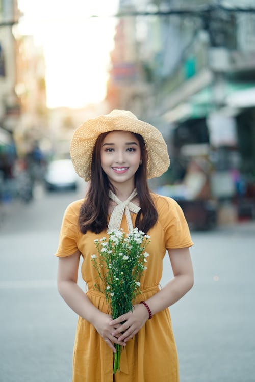 Free Selective Focus Photography Of Woman Holding Flowers Stock Photo