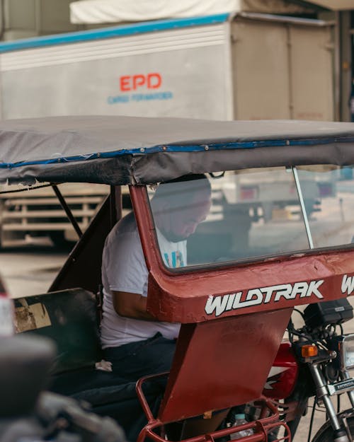 Man Sitting Inside a Tricycle Transport Vehicle on a Street in City in Philippines
