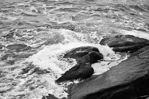 Free Monochrome image of ocean waves crashing against rocky shoreline, highlighting the power of nature. Stock Photo