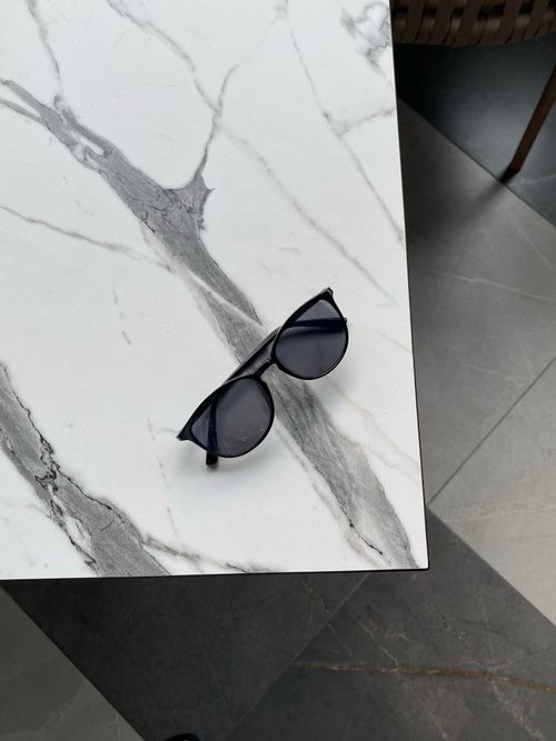 Free Sleek black sunglasses resting on elegant marble surface, perfect for fashion inspiration. Stock Photo