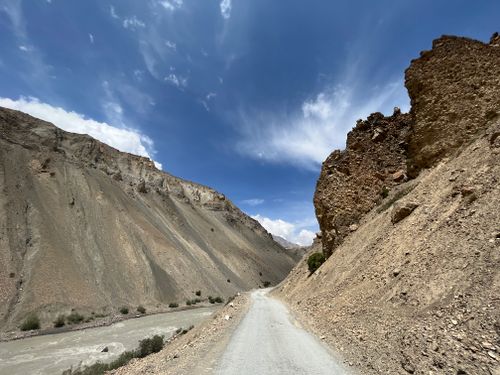 Free A breathtaking Himalayan landscape featuring a winding road through rocky terrain under a clear blue sky. Stock Photo