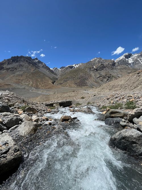 Free Crystal clear stream flowing through rugged mountains under a bright blue sky in Dhar Latothanmo, HP, India. Stock Photo