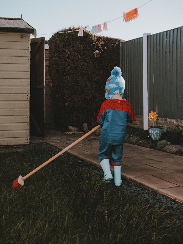 Child With Broom On Lawn