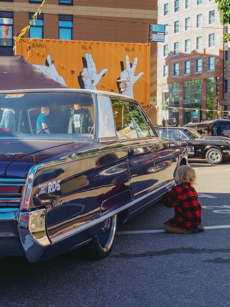 Child Looking At Retro Car On Street