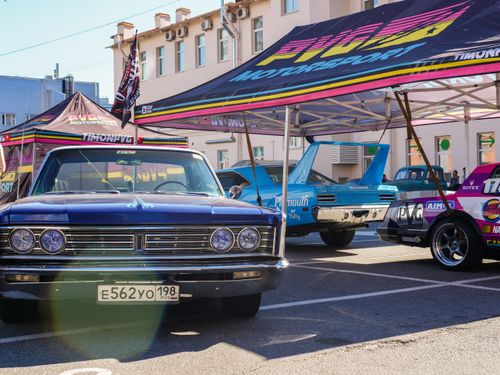 Free A collection of classic cars showcased at an outdoor automotive event with tents. Stock Photo