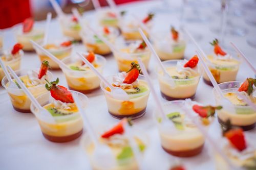 Free Close-up of vibrant fruit custard desserts with strawberries and kiwi in plastic cups. Stock Photo