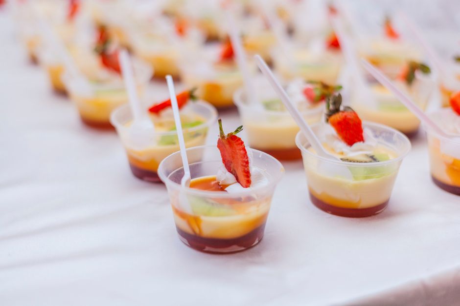 Rows of red and blue jello shots in small plastic cups, chilled and set, arranged on a tray.