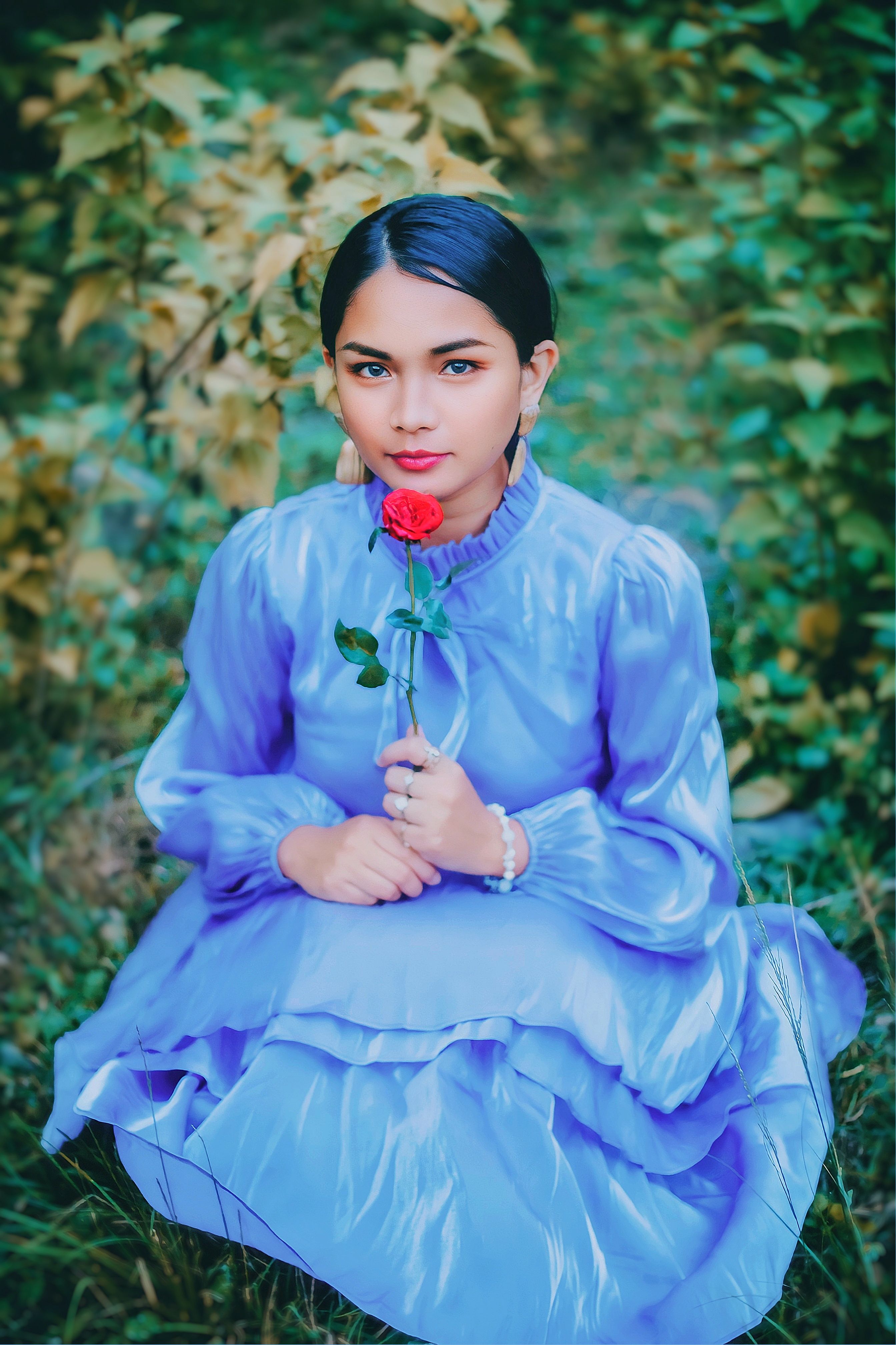 Woman in Red and Black Dress Sitting on the Ground Beside the Flowers ...