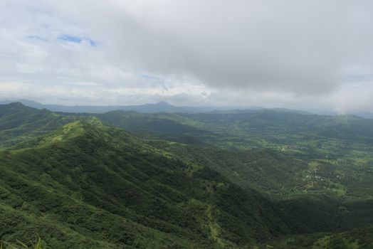 Experience the lush green Sahyadri Mountains in Pune, India, enveloped by monsoon clouds.